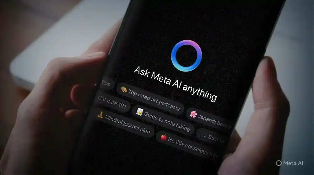 The alt text for this image could be: "A person holding a smartphone with the Meta AI interface on the screen, displaying a prompt to 'Ask Meta AI anything' and showing various suggested topics below."